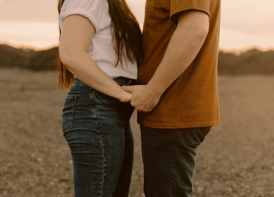Una donna e un uomo si tengono per mano (fotografia: Brooke Cagle su Unsplash)