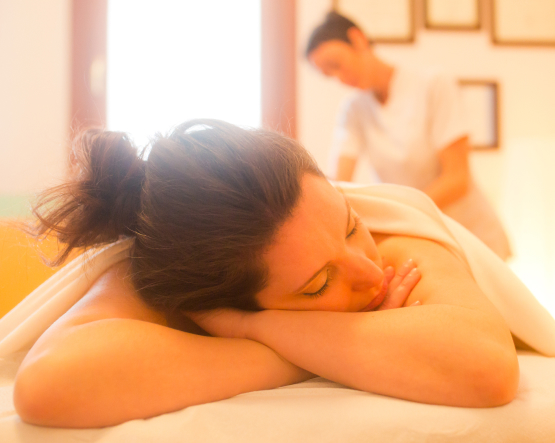 Una donna giace rilassata sulla panca da massaggio