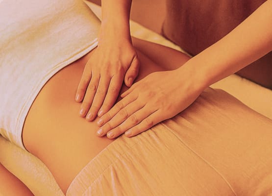 Due mani massaggiano il ventre di una donna (fotografia creata con ChatGPT)